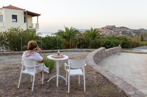 a woman taking a picture of a table and chairs at Lampetos Houses Molyvos in Mithymna