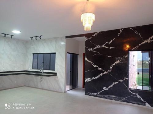 a kitchen with a black and white marble wall at casa com piscina, 03 quartos, ótima localização! in Bonito
