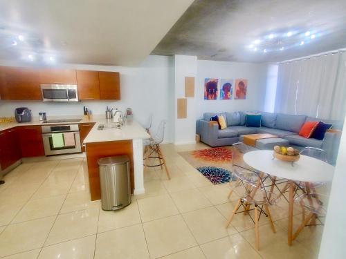 a kitchen and living room with a blue couch at Beautiful 1BD 1BTH at Midblock FREE PARKING in Miami