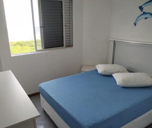 a bedroom with a blue bed and a window at Apartamento de cobertura na beira mar e de frente para o mar. Vista maravilhosa. in Pontal do Paraná