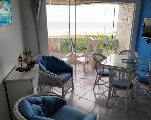 a living room with a table and chairs and a view of the ocean at Apartamento de cobertura na beira mar e de frente para o mar. Vista maravilhosa. in Pontal do Paraná