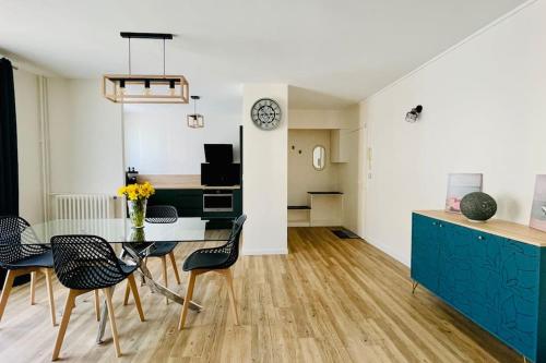 - une cuisine et une salle à manger avec une table et des chaises dans l'établissement Bel appartement proche de Paris, à Villemomble