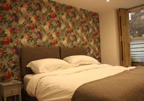 um quarto com 2 camas e um papel de parede floral em Vintage Beach House em Lower Largo