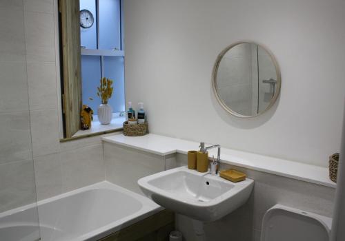a white bathroom with a sink and a mirror at Vintage Beach House in Lower Largo