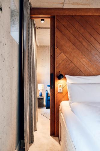 a bedroom with a bed with a wooden headboard at Villa Viva - ein Haus das Brunnen baut in Hamburg