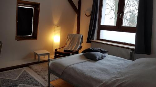 a bedroom with a bed and a chair and a window at Grüne Oase in Dahlewitz