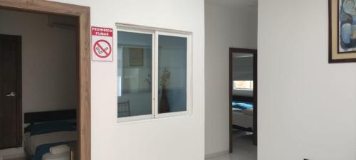 a room with a window and a door with a sign at Hotel Mykonos Manta in Manta