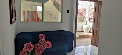- un canapé bleu avec un vase de fleurs dans l'établissement Hotel Mykonos Manta, à Manta