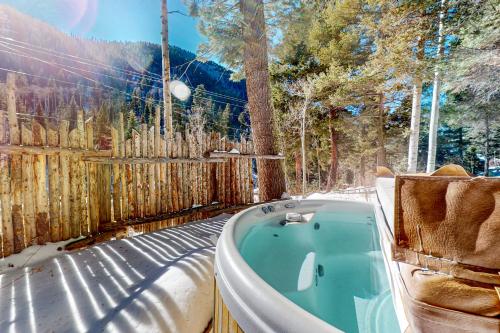 a bath tub in a yard with a fence at Ridgerunner Cabin in Taos Ski Valley