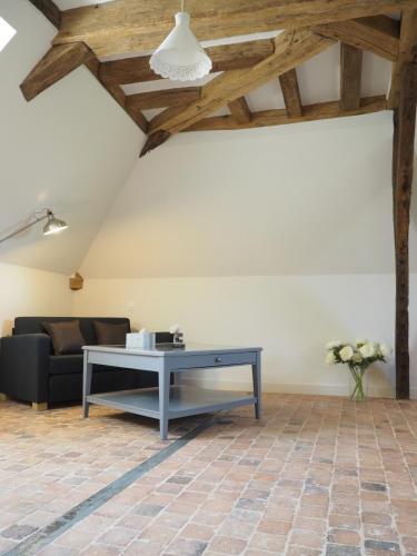 un salon avec un canapé et une table dans l'établissement Les Grands-Aulnais, à Cossé-le-Vivien