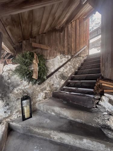 a stairway with a lantern and a christmas wreath at Ferienhaus Alpenglück in Wenns