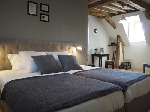 sypialnia z dużym łóżkiem na poddaszu w obiekcie Les Grands-Aulnais w mieście Cossé-le-Vivien