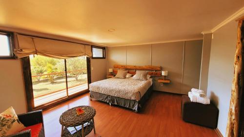a bedroom with a bed and a large window at Hotel Uka Mana in Hanga Roa