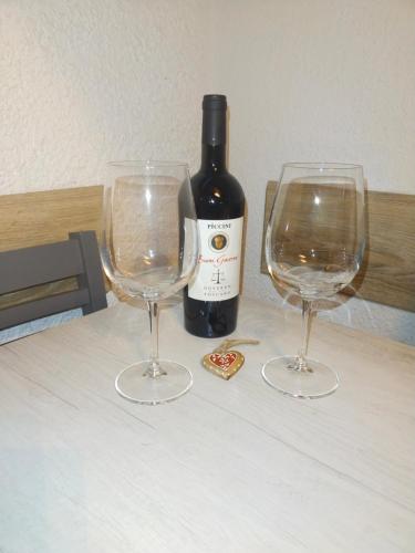 uma garrafa de vinho e dois copos de vinho numa mesa em Appartamento gaiulin em Pinzolo
