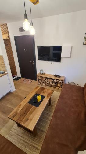 a living room with a coffee table and a flat screen tv at Apartmani Šišarka Jahorina in Jahorina