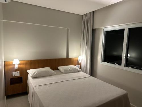 - une chambre avec un lit blanc et une fenêtre dans l'établissement Salinas Exclusive Resort, à Salinópolis