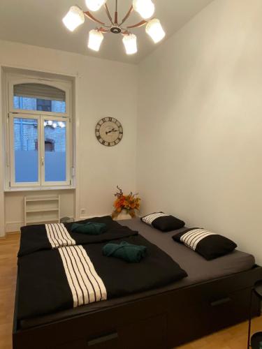 ein Schlafzimmer mit einem großen Bett mit einer Uhr an der Wand in der Unterkunft Modernisierte, traumhafte Wohnung in zentraler Lage in Wiesbaden