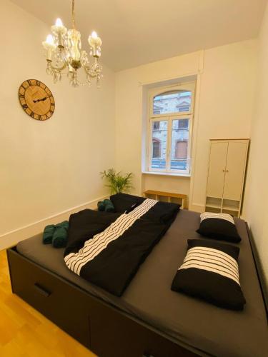 a large bed in a room with a clock on the wall at Modernisierte, traumhafte Wohnung in zentraler Lage in Wiesbaden