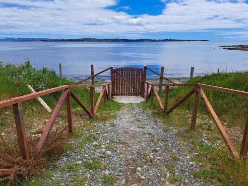 a wooden gate next to a body of water at Cabañas Tripanko Chiloe in Ancud