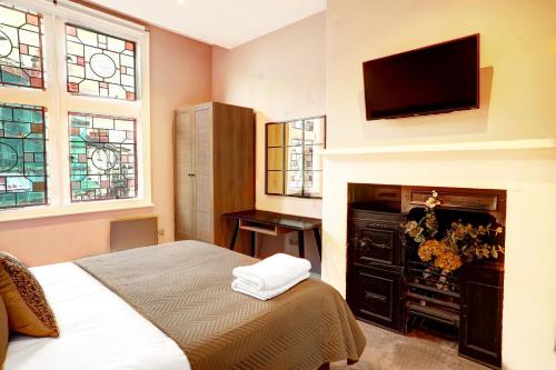 1 dormitorio con 1 cama y TV de pantalla plana en Old Market Apartments en Altrincham