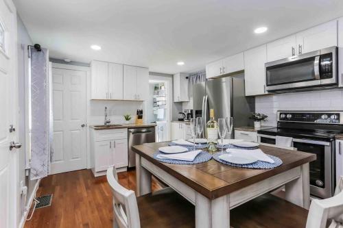 a kitchen with white cabinets and a wooden table at Two Bedroom Apartment on Forestville Bristol in Bristol