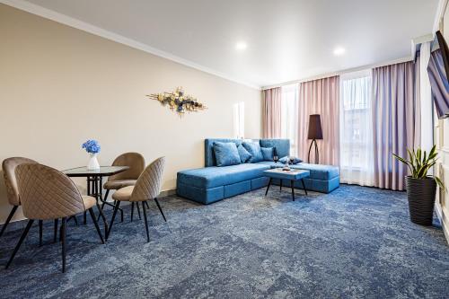 ein Wohnzimmer mit einem blauen Sofa und einem Tisch in der Unterkunft ApartReserve Avtorskiy in Iwano-Frankiwsk