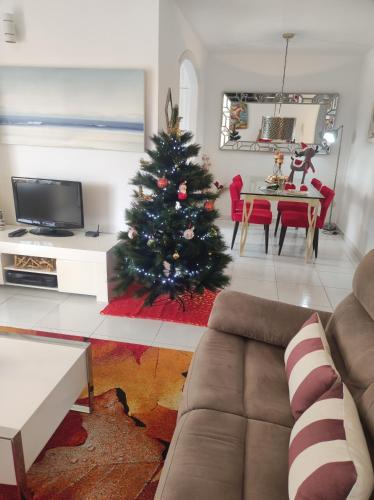 a christmas tree in a living room with a couch at Penthouse Sabina mit Jacuzzi in Callao Salvaje