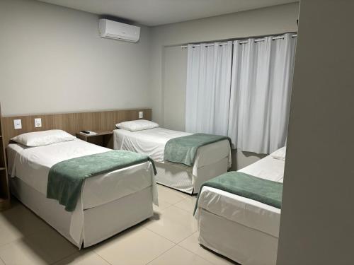 a hospital room with two beds and a window at Mahle Comfort Hotel in Campina Grande do Sul