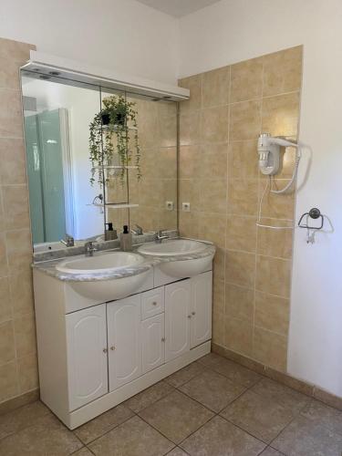 ein Badezimmer mit zwei Waschbecken und einem großen Spiegel in der Unterkunft Villa provençale 8 personnes in Ventabren