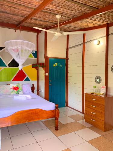a bedroom with a bed with a blue door at Le Petit Paradis in Roseau