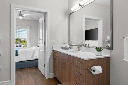 a bathroom with a sink and a mirror and a bed at Beverly Hills Suite Penthouse The Gulch in Nashville