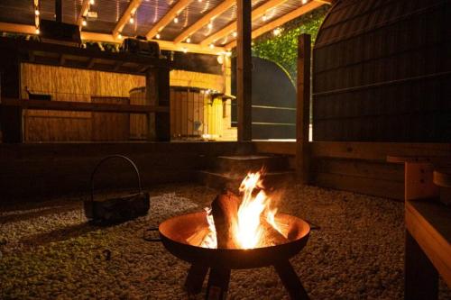 a fire pit in the middle of a patio at Portside Pasture - (Luxury Cabin) in Portpatrick