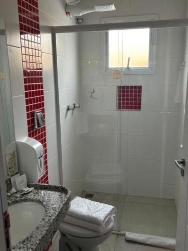 ein Bad mit einer Dusche, einem WC und einem Waschbecken in der Unterkunft Mahle Comfort Hotel in Campina Grande do Sul