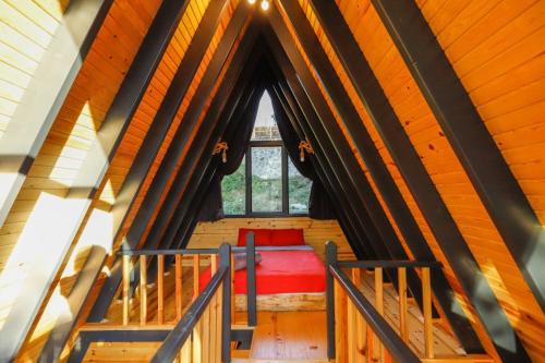 ein Zimmer mit einem roten Bett in einem Zimmer mit einem Fenster in der Unterkunft SAPANCA LİFE GARDEN BUNGALOV in Sapanca