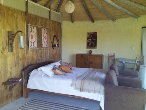1 dormitorio con cama y sofá en Buda de uco en Tunuyán