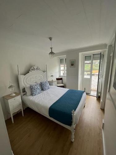 a bedroom with a large bed with blue and white sheets at Casa da Ti Cristina in Pomares