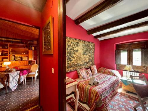 Habitación roja con cama y mesa en La Morada Del Unicornio, en Calonge