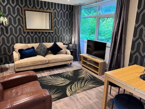 a living room with a couch and a television at 4 Bedroom House by Mesh Accommodation Short Lets Canterbury For Contractors And Corporate Stays For Short & Long Term Stays in Kent