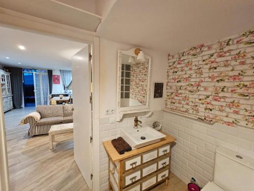 een badkamer met een wastafel en een woonkamer bij LokalHome in Roda de Bará