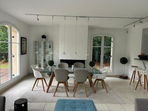 une salle à manger avec une table et des chaises dans l'établissement Maison individuelle prVersailles, à Villennes-sur-Seine