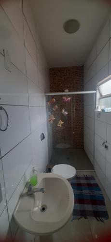 een kleine badkamer met een wastafel en een douche bij Lugar Certo Tranquilo in Itabira