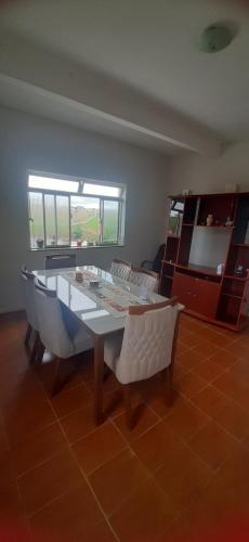 een woonkamer met een tafel en stoelen bij Lugar Certo Tranquilo in Itabira