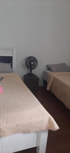 een slaapkamer met 2 bedden en een tafel in de hoek bij Lugar Certo Tranquilo in Itabira
