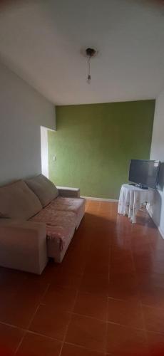 een woonkamer met een bank en een flatscreen-tv bij Lugar Certo Tranquilo in Itabira
