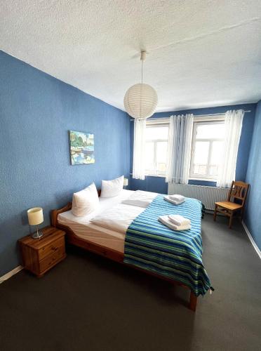 a bedroom with a large bed with a blue wall at Ferienhaus Zum Lochstein - FW Kornboden in Sankt Andreasberg