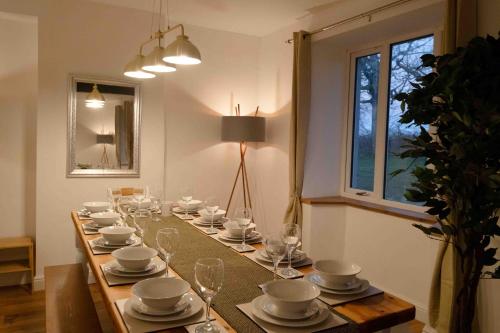 米勒姆的住宿－Hycemoorside House，长桌,上面有盘子和杯子,盘子