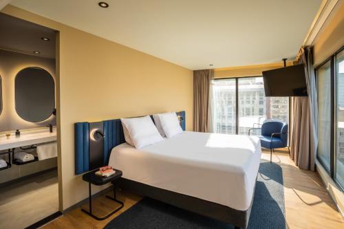 a hotel room with a large bed and a desk at Novotel México City Centro Histórico in Mexico City