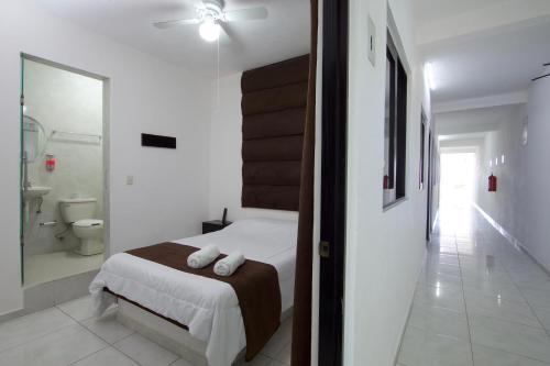a white bedroom with a bed and a bathroom at Hotel Villa 12 TX in Tequisquiapan