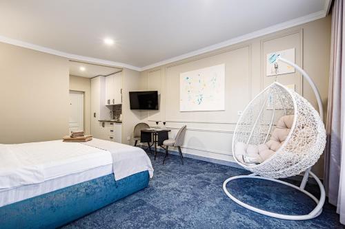 a room with a bed and a hanging chair at ApartReserve Avtorskiy Aparthotel in Ivano-Frankivsk