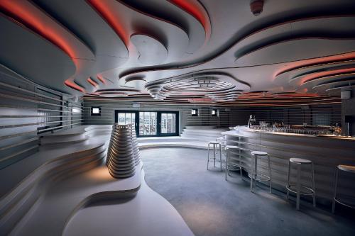 a room with a bar with stools in it at Villa Viva - ein Haus das Brunnen baut in Hamburg